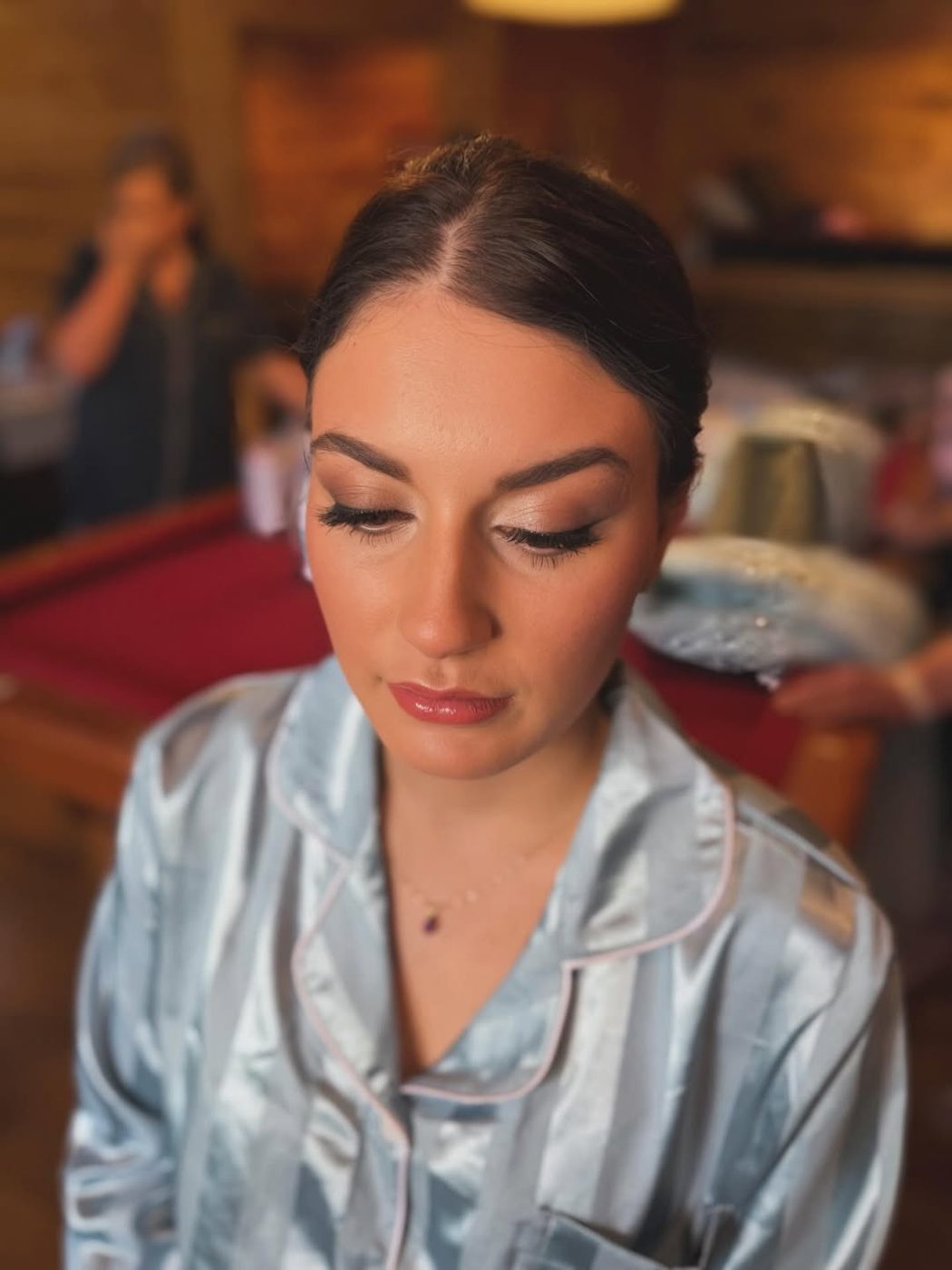 Sleek pulled-back bridal hair with defined eye makeup